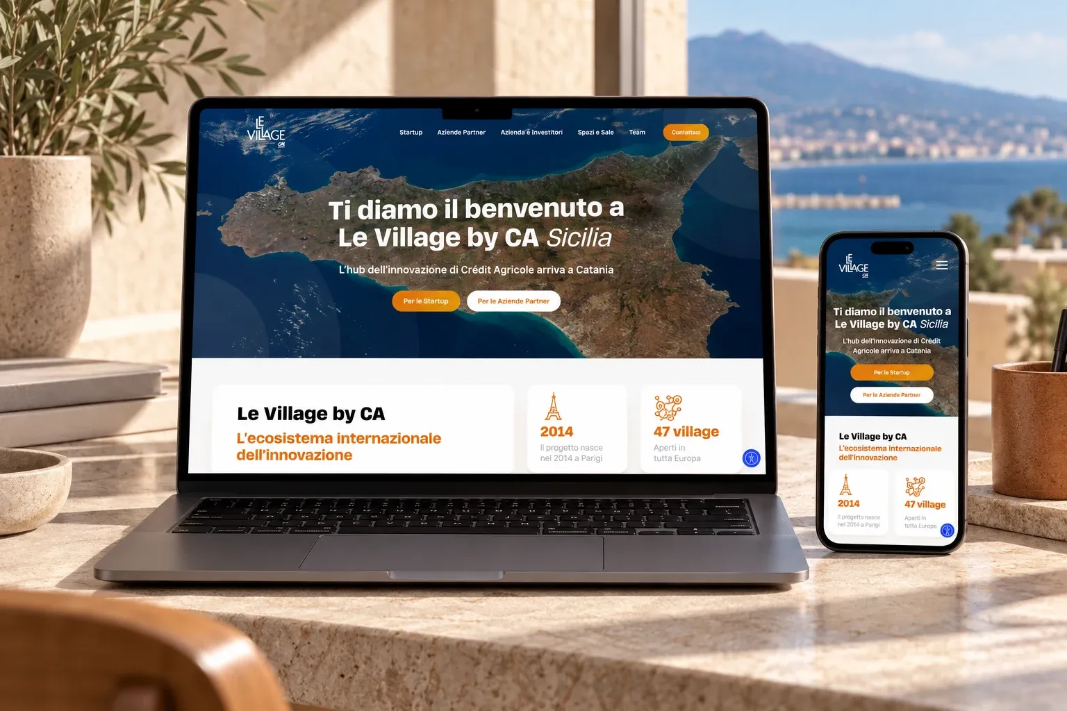 Le Village by CA Sicilia website home page on a MacBook Pro and an iPhone